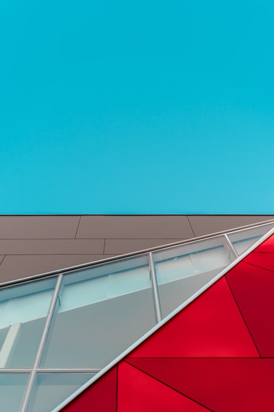 蓝天下红、褐、白玻璃幕墙建筑浅焦摄影